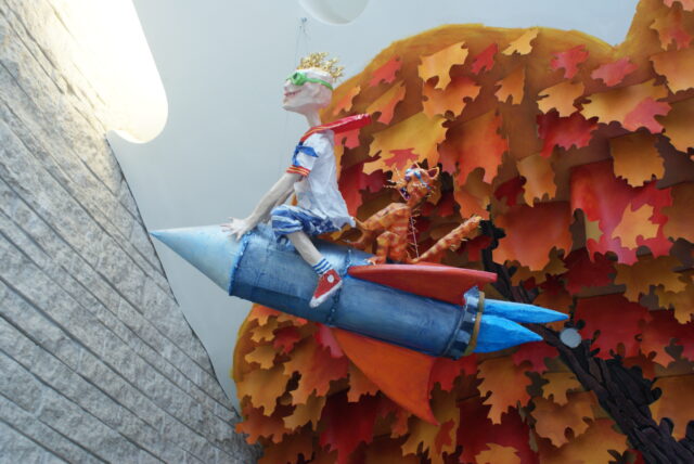 Sculpture d'un garçon et d'un chat sur une fusée