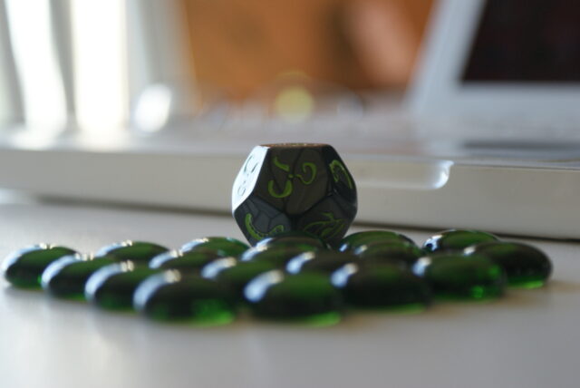 Dé et billes plates vert d'un jeu Chtulhu